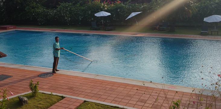 stock image of man cleaning and maintaining residential pool